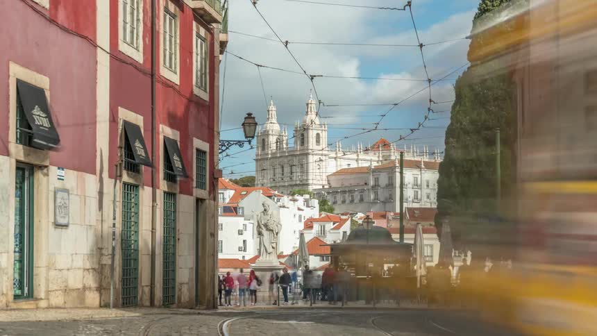Time lapse footage of traffic and pedestrians on the streets of alfama in lisbon