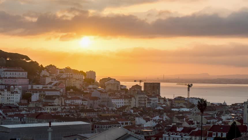 Time lapse of sun setting over the ocean close to a coastal town