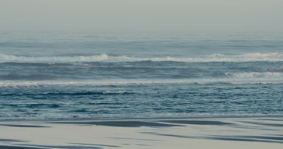 Waves are splashing as they roll into shore