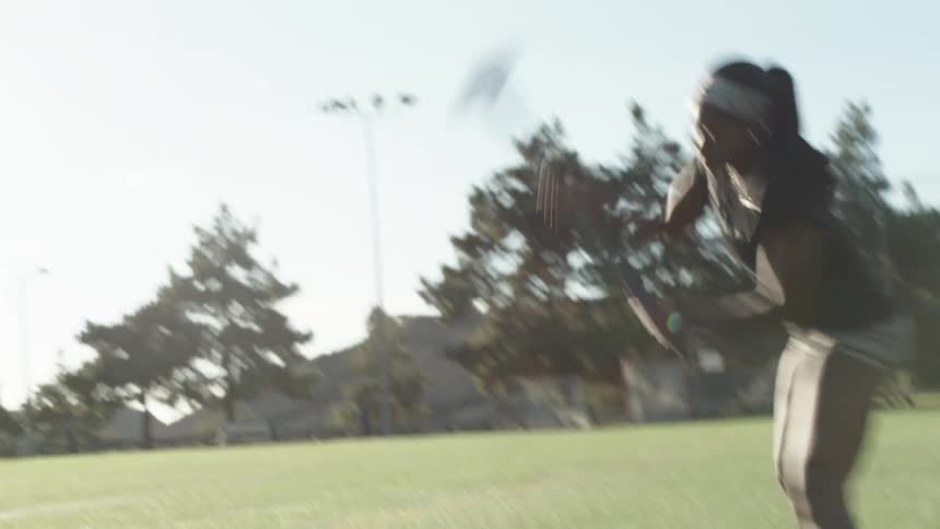 A female athlete uses a sledge hammer to hit a tractor tire