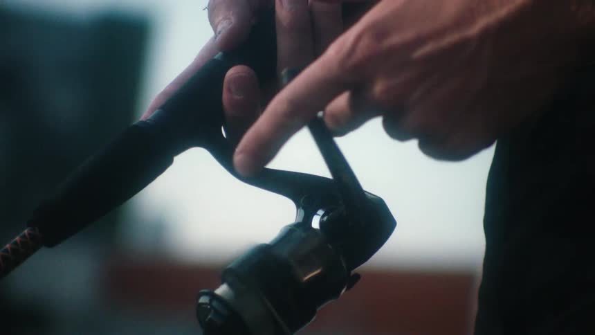 A man is holding a fishing pole indoors