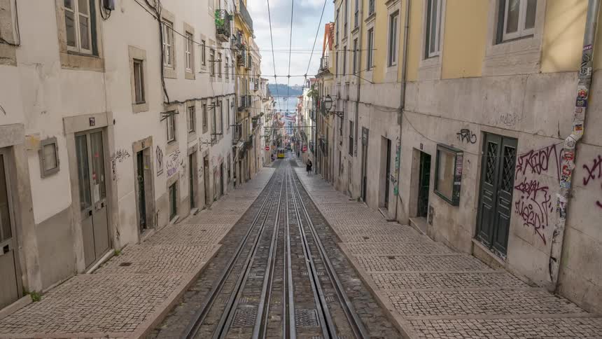 Time lapse of a yellow tram on a narrow street of alfama district in lisbon portugal