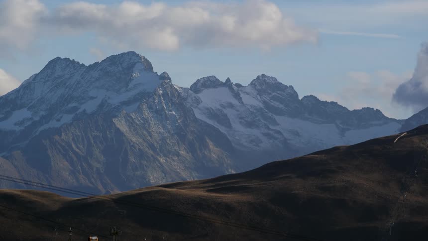 Snow covered mountain ridge under a cloudy sky