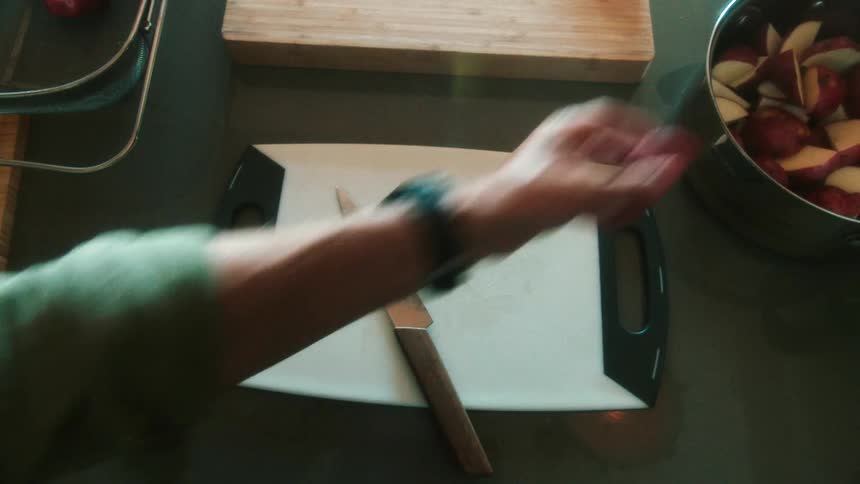 Closeup overhead view of man tossing cut red potatoes in a large pot