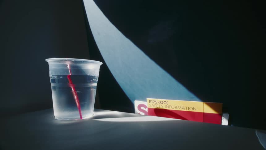 A cup of water is displayed next to a box