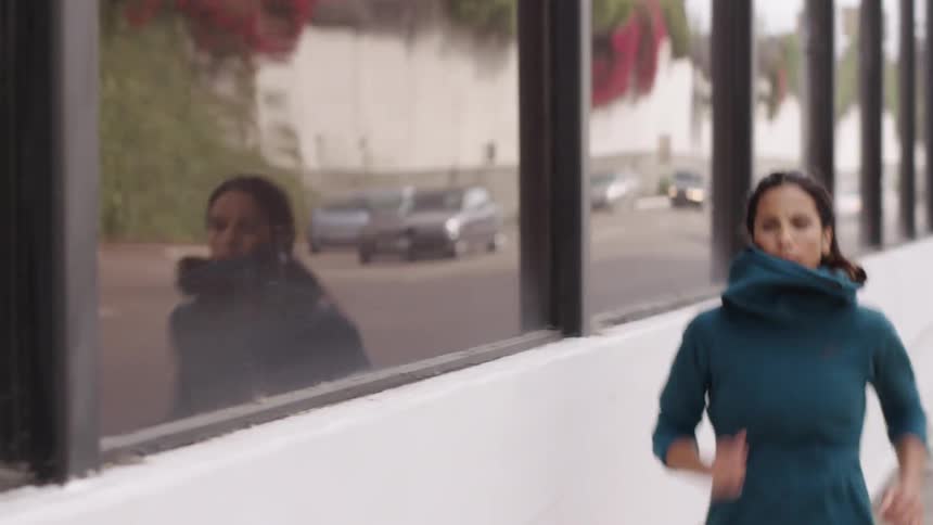 Woman jogging down a city street