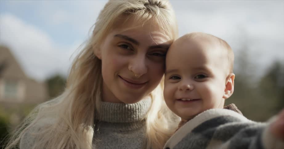 A mom holding her little girl smiles and enjoys babys scent