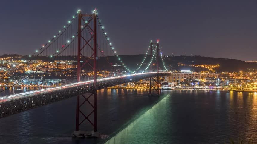 Suspension bridge connecting a city over a river with cars driving by it