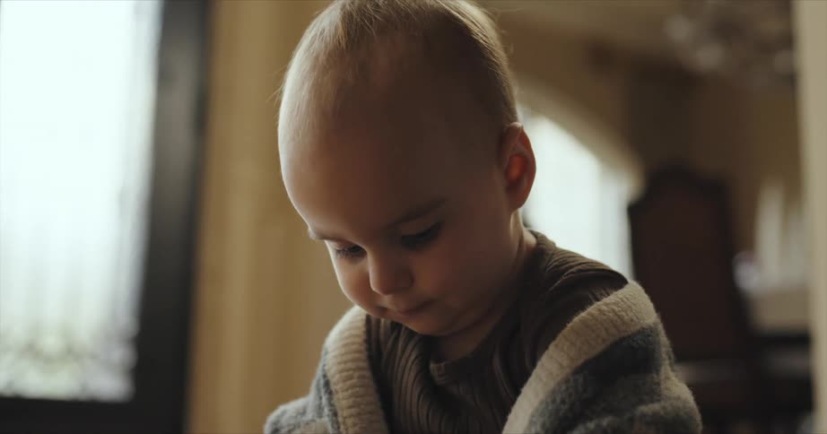 A baby plays on the floor near the front door of her home
