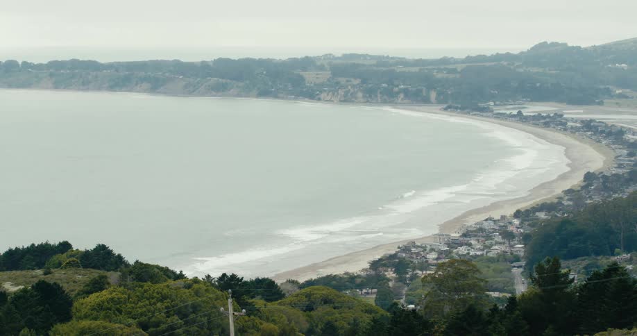 Ocean waves come to shore on stinson beach on a hazy day