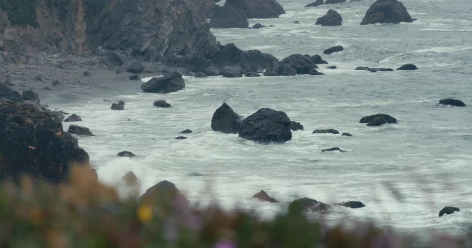 Waves roll onto the shore and splash against rocks