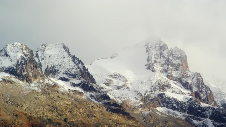 Snow covered mountains high in a cloudy sky