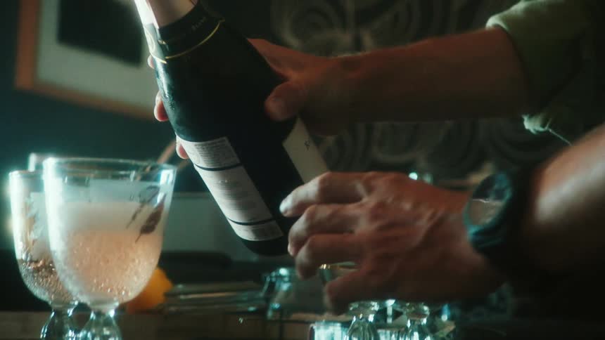 A man is pouring glasses on the table