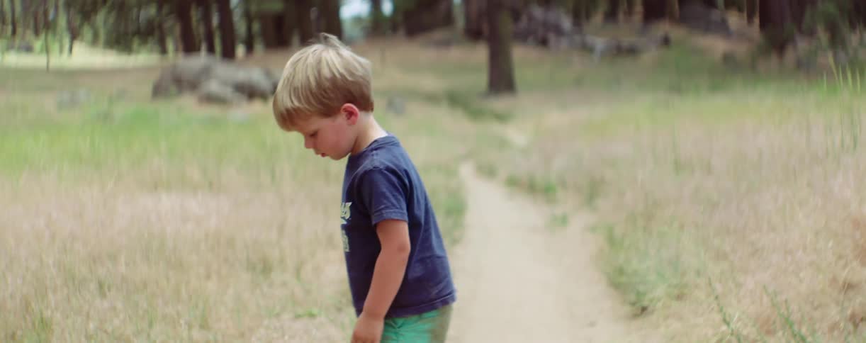 Little boy walking around on a dirt trail