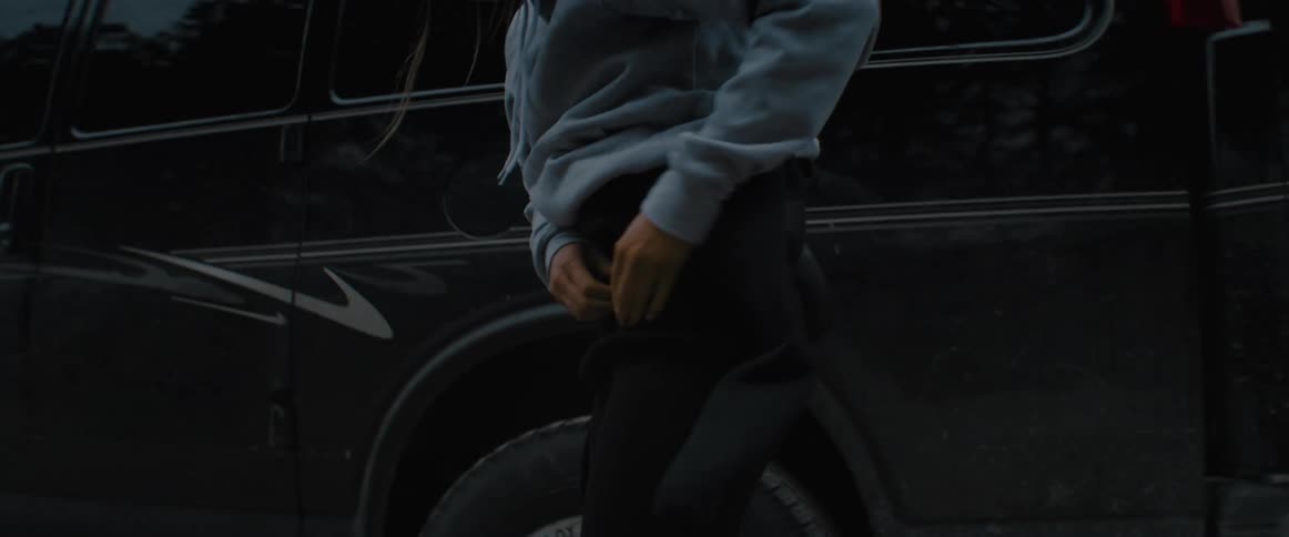 A man putting on clothes outdoors