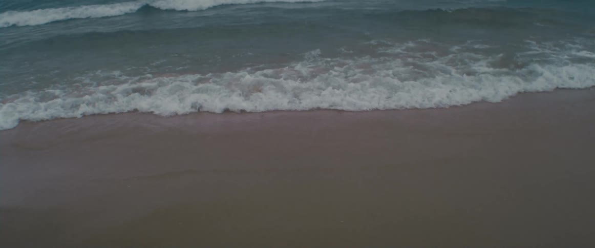 Ocean waves rolling and breaking on a sandy beach