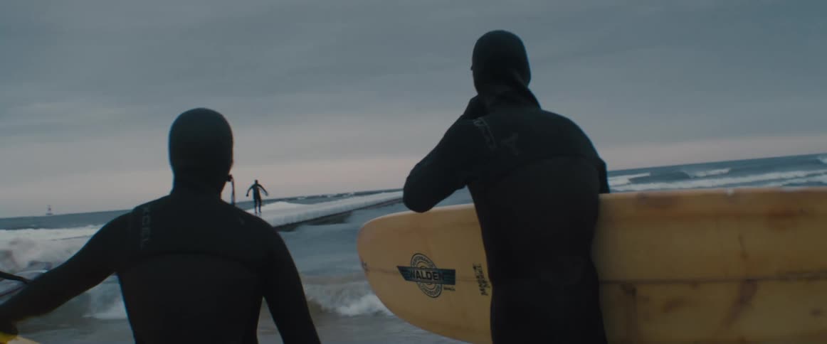 People getting ready to go surfing in the ocean