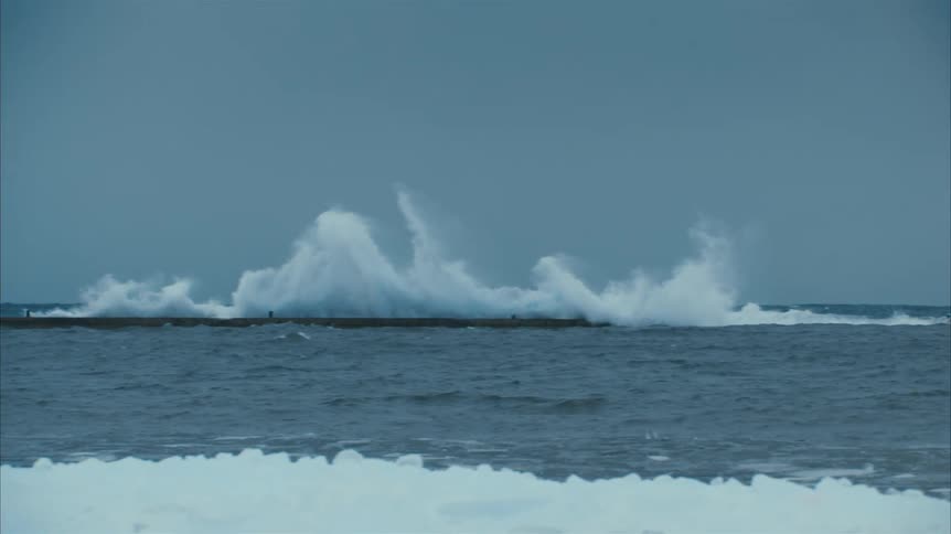 Waves crashing on a breakwater close to the coast at daytime