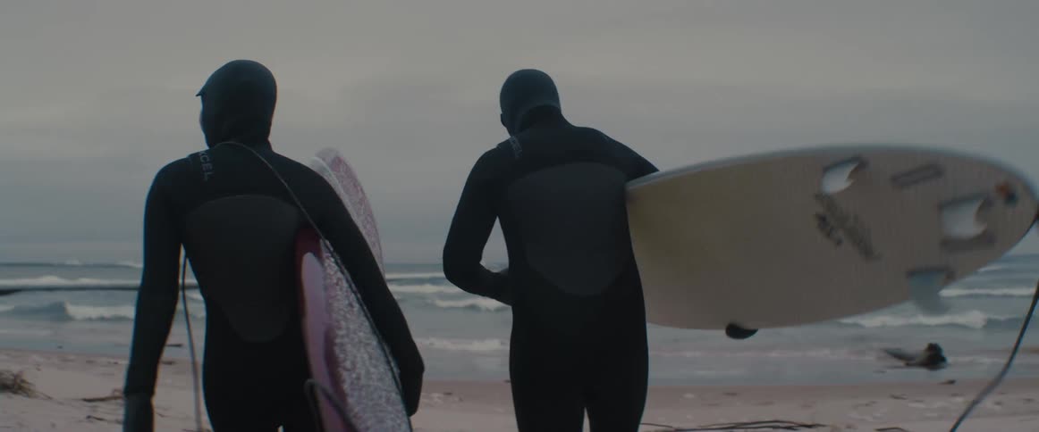 People with surfboards heading into the ocean