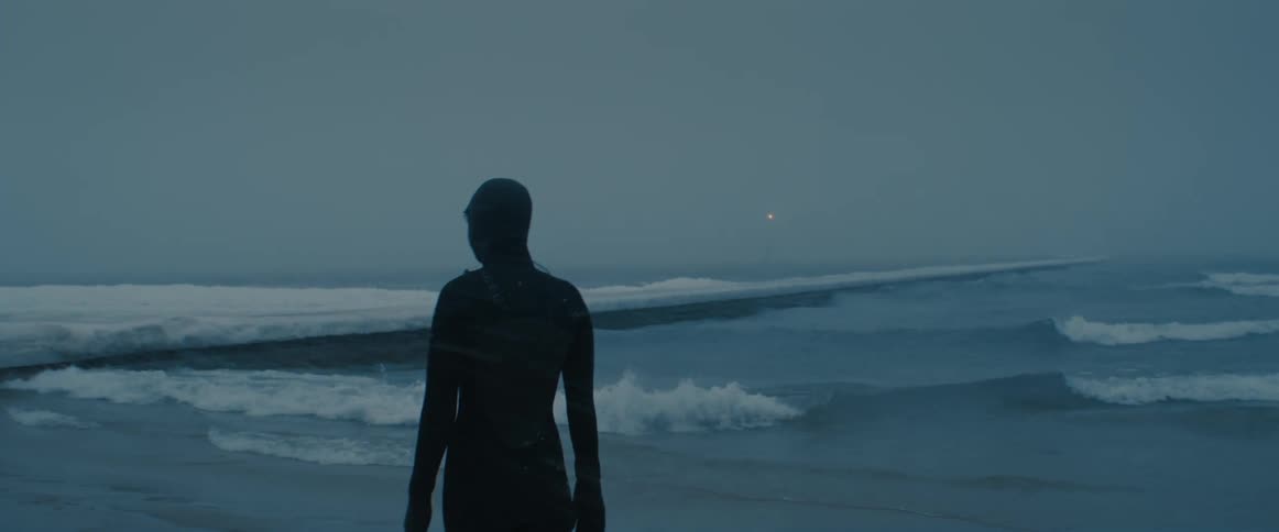 A person getting ready to go into the ocean in the winter