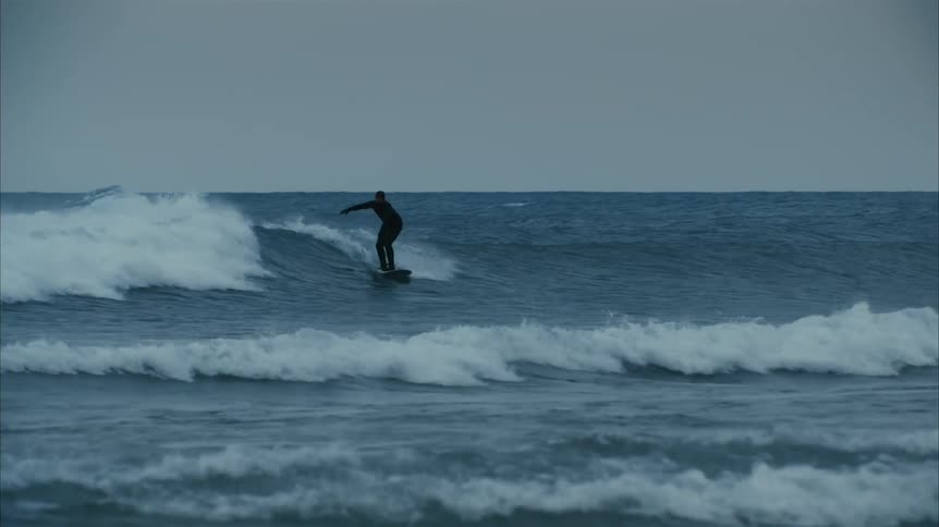 A view of a person surfing in the winter