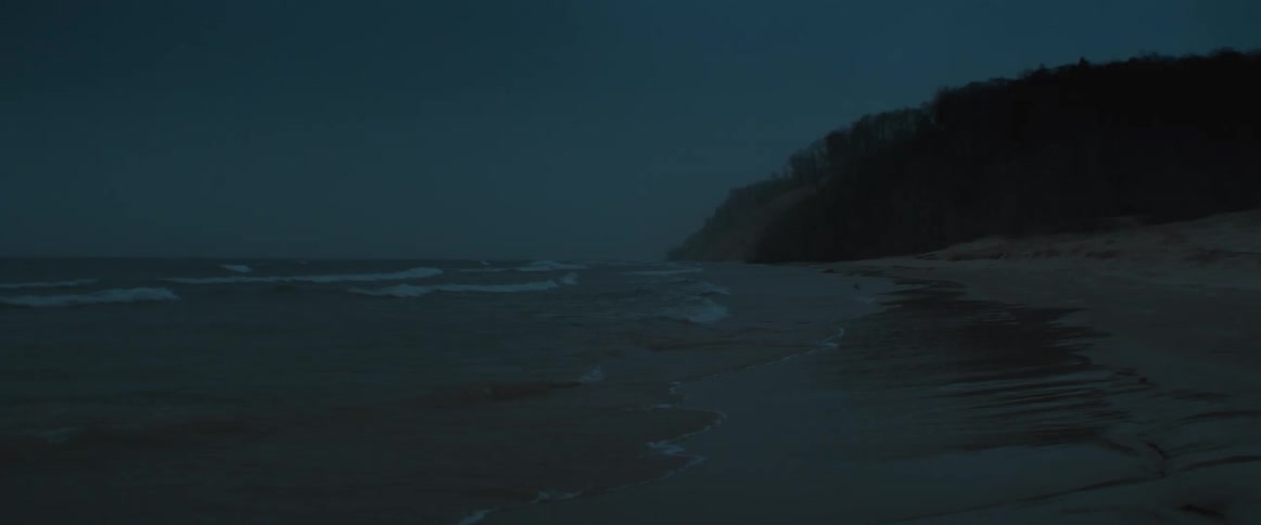 Ocean waves are moving towards the coast at night