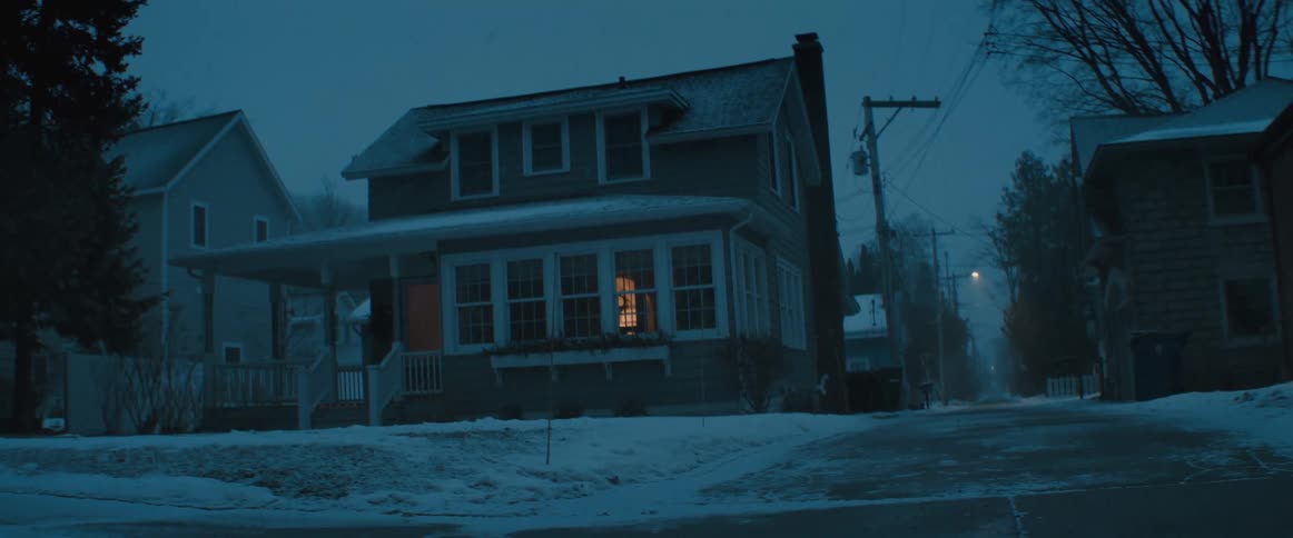 Its snowing in a suburban area at night