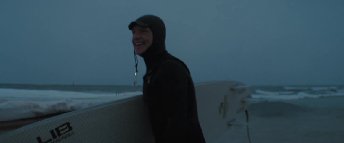 A person is walking on the beach at dusk