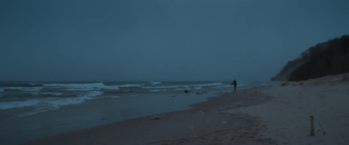 People are walking on the coast of the beach at night