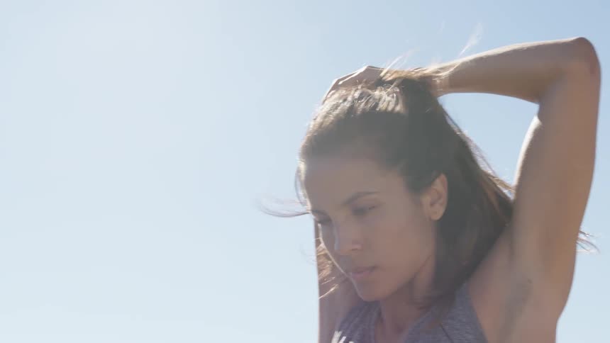 A woman is stretching on a sunny day