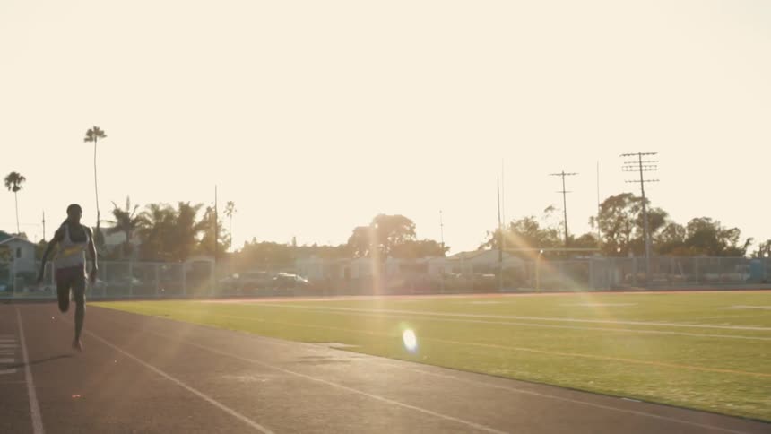 Woman running on a football field track