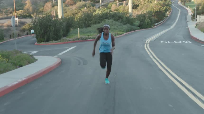 A woman is running down the middle of a road