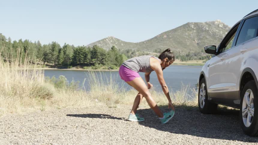 Woman stretching by a lake
