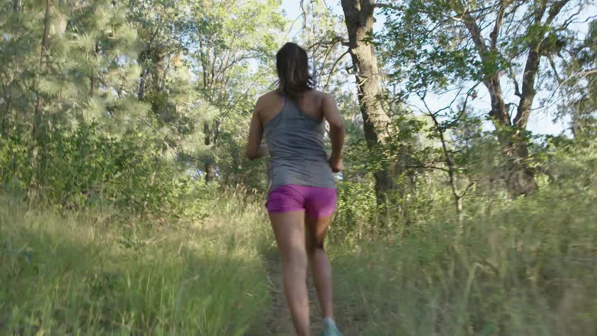 Person jogging on a wilderness trail and then breaking into a sprint