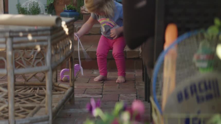 A girl plays with her pull toy on the brick walkway