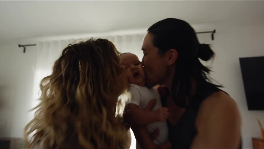 Two people kissing their babies