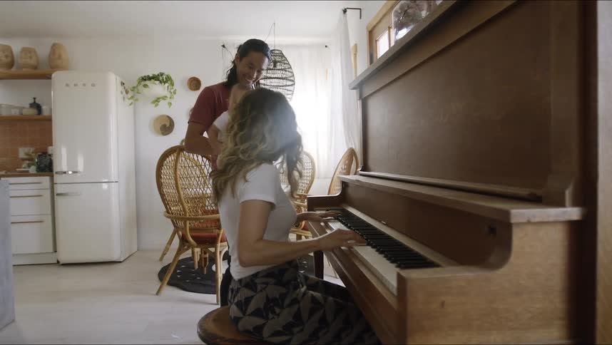 A mother father and baby playing piano