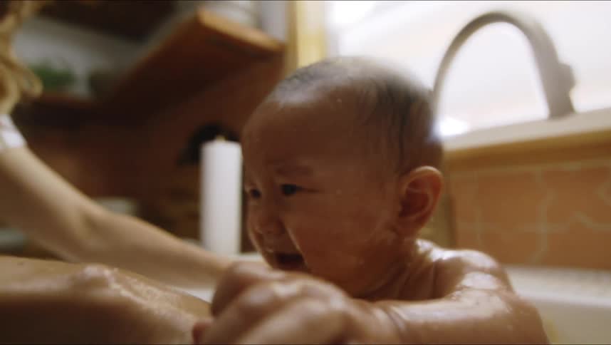 A mother bathing her baby