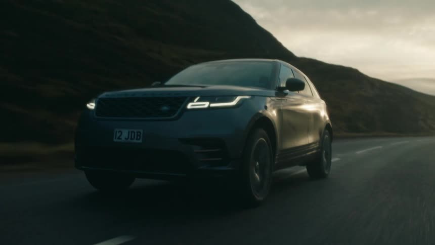 A car is driving on a road at dusk