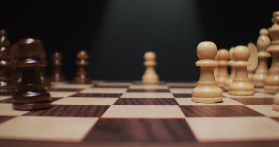 A close of view of chess game in a shadowy room where a pawn slowly slides into view
