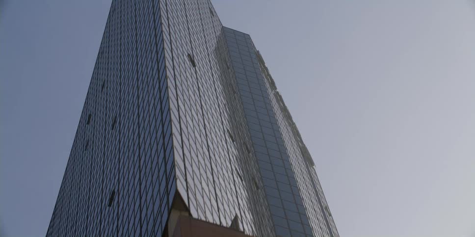Skyscraper with large lettered label towers over palm trees