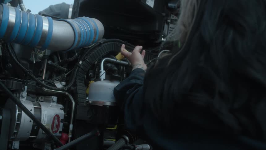 A woman is changing oil on a car