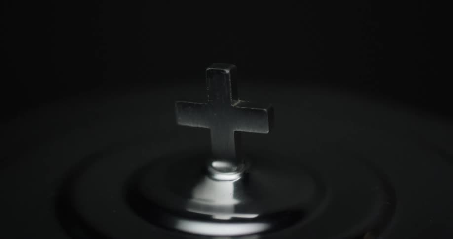 A silver cross is in the dark