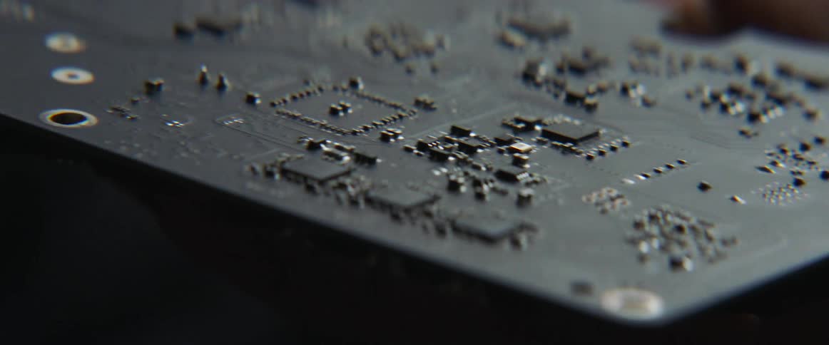 Caucasian hand holds a rectangular circuitry board