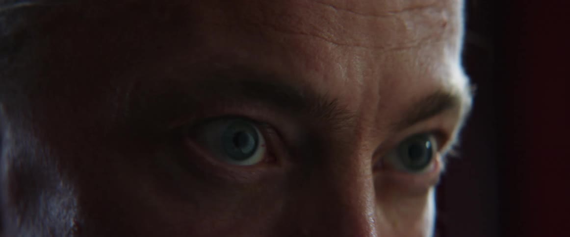 Middle aged and blue eyed man with gray ponytail works out in gym