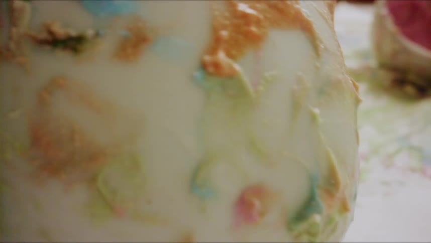 Blue and white icing in a bowl that is sitting on a table