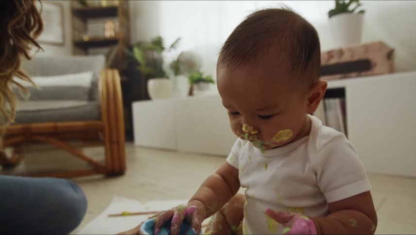 A mother and her baby playing with paint