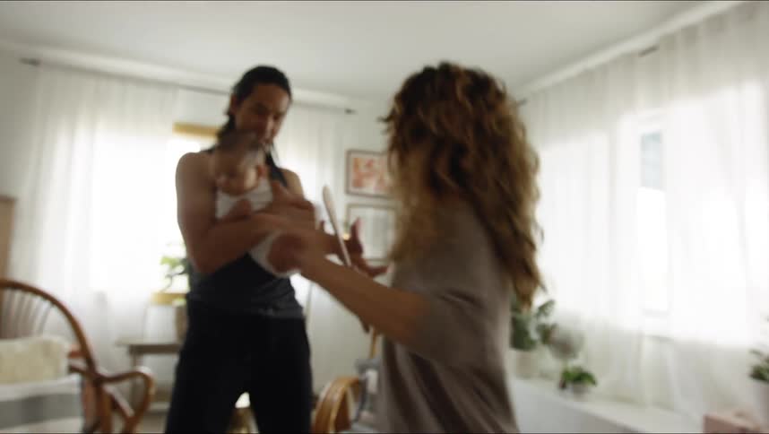 Happy couple signing and dancing with their baby in the living room