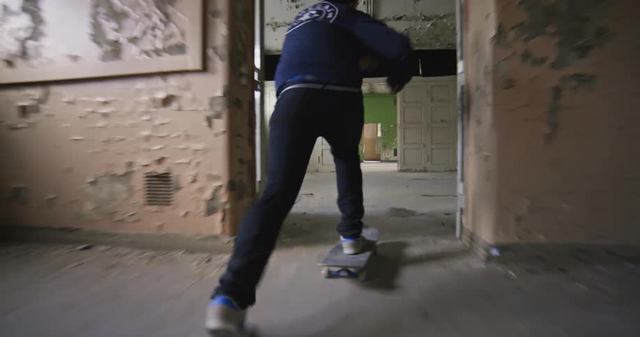 A man is skateboarding through the building