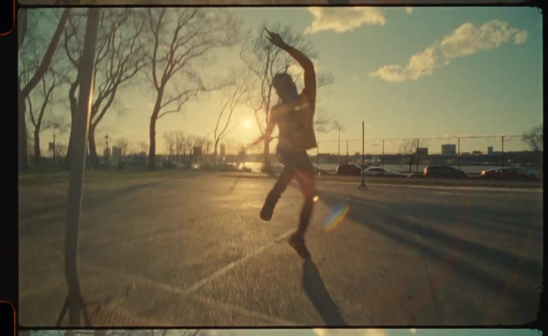 Black man dancing alone at a basketball court at sunset